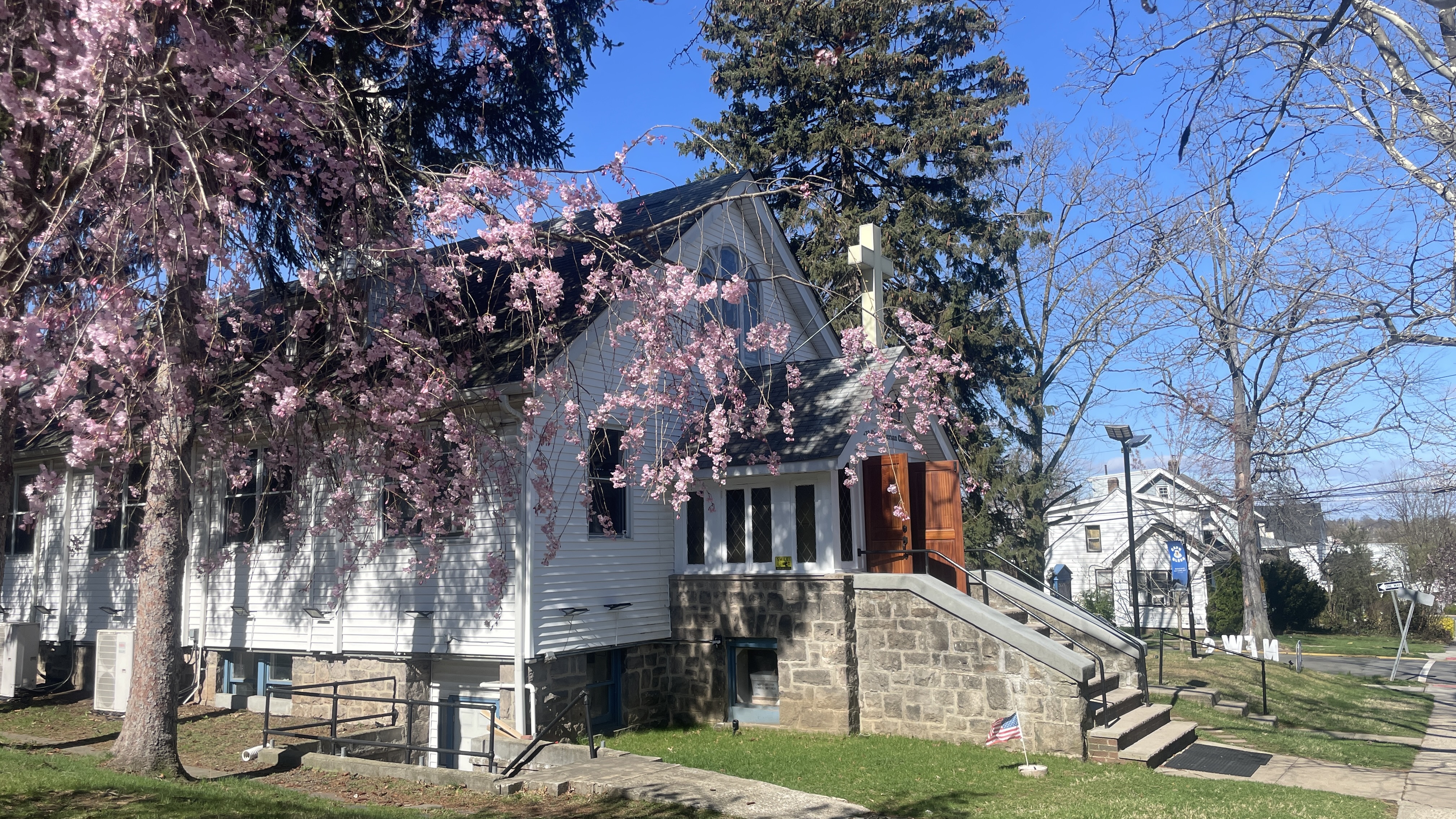 White clapboard sanctuary, bell tower, and church sign on Palisades Boulevard