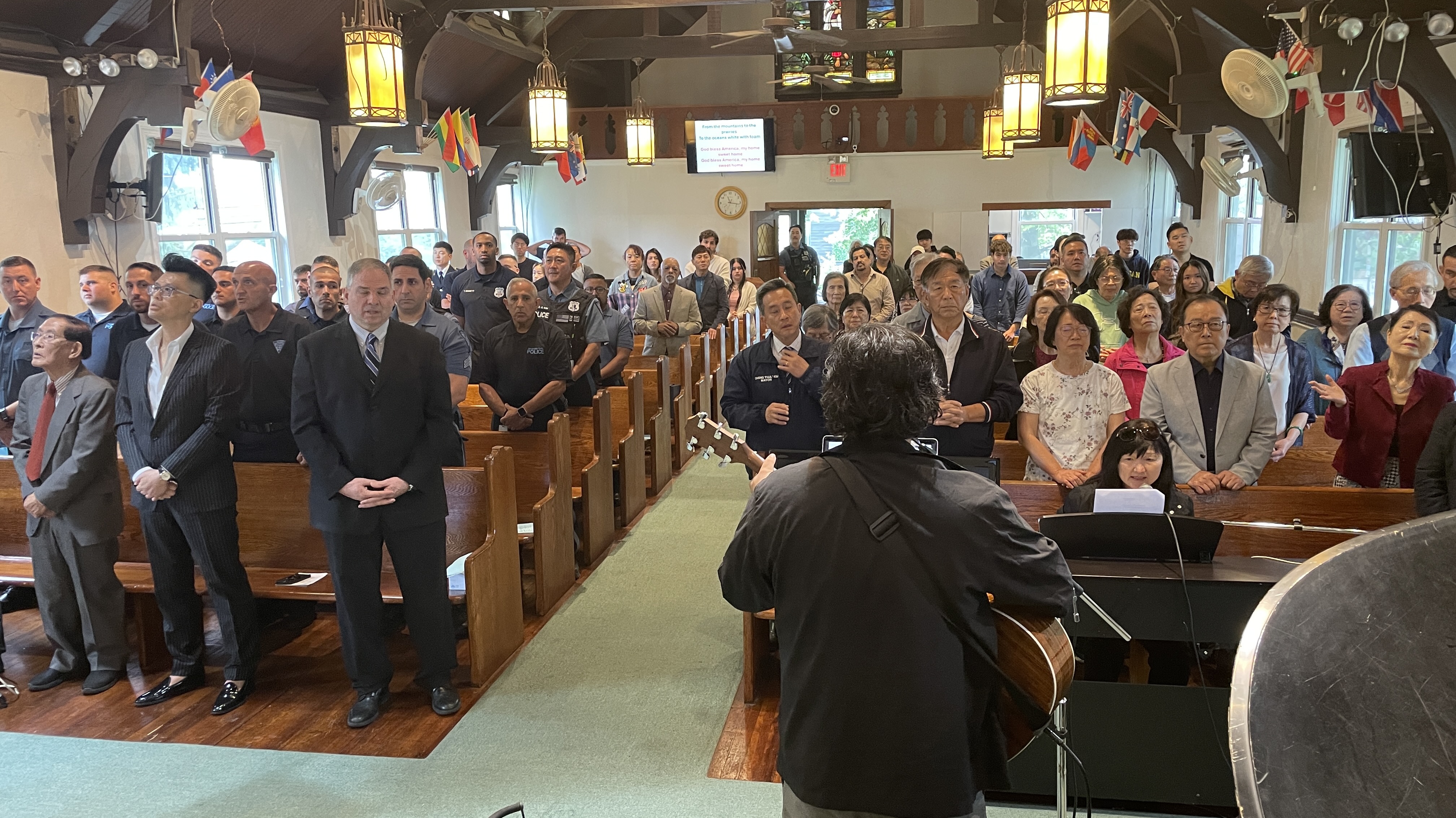 The congregation filling the sanctuary under international flags