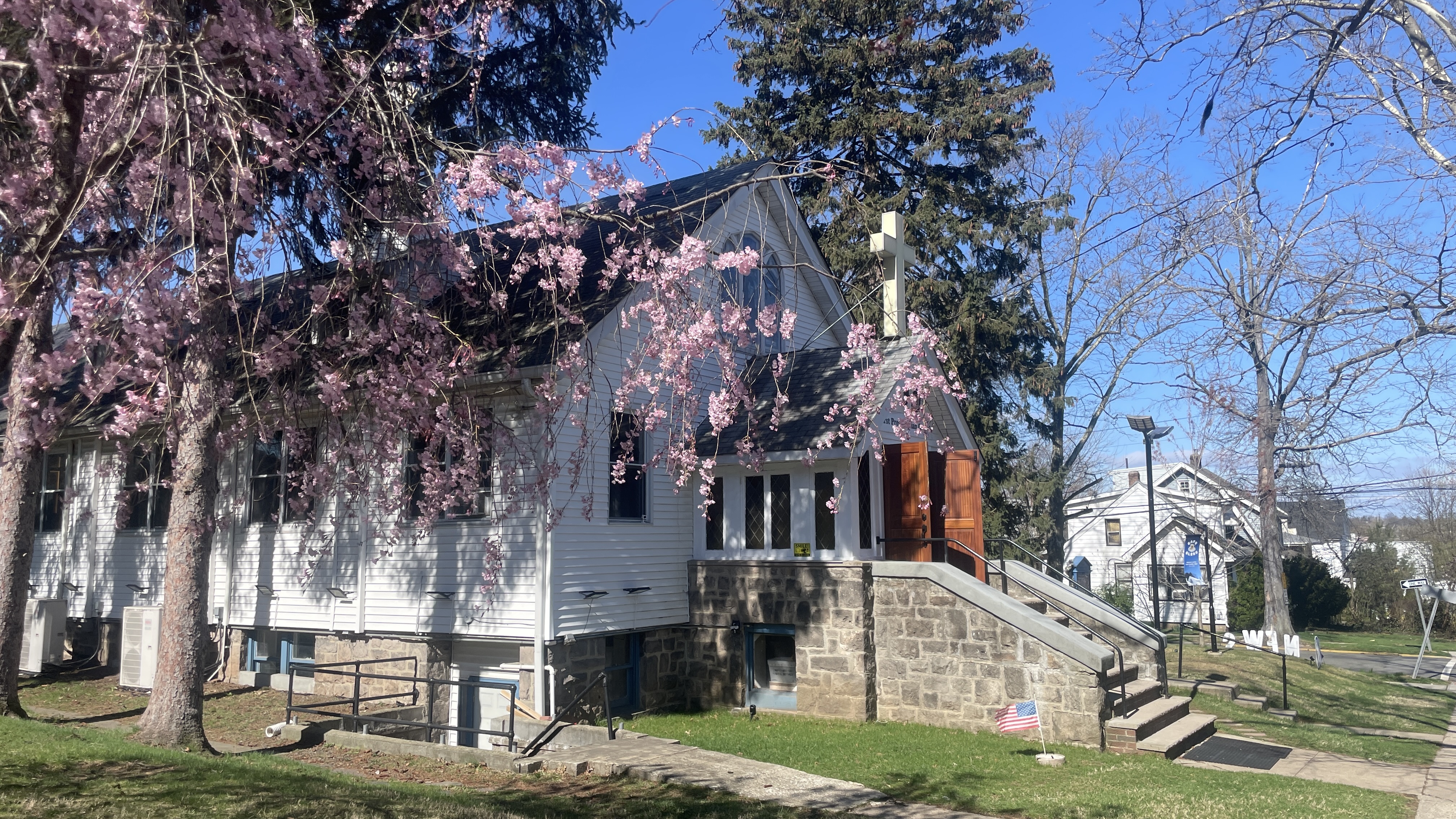 First Presbyterian Church Palisades Park in spring, with cherry blossoms and a cross on the roof